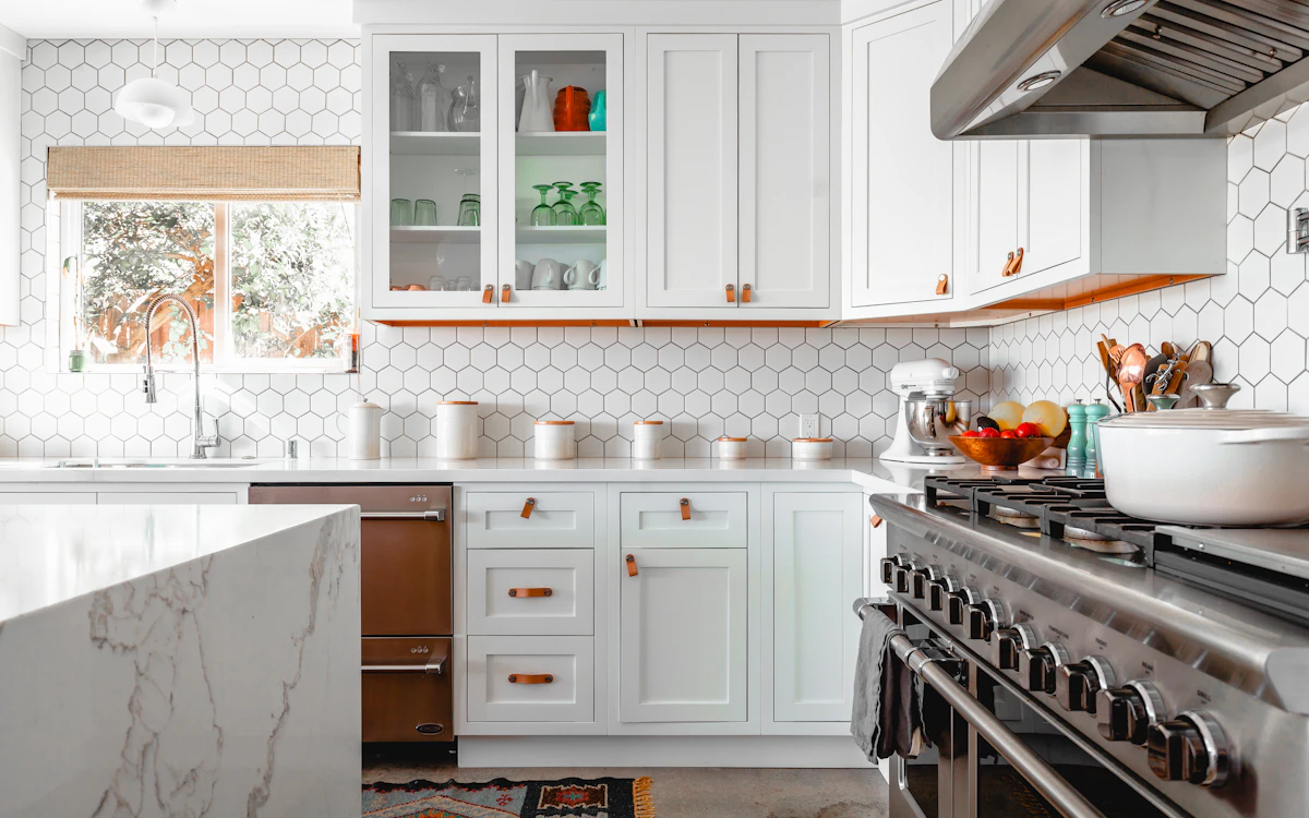 White kitchen cabinets, tiled splashback and a kitchen island