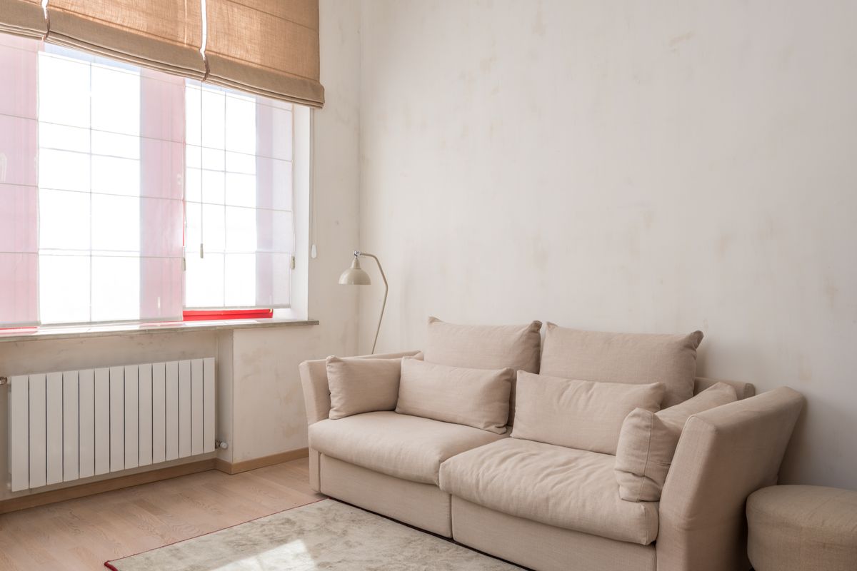 Beige sofa beside a large window in a softly lit living room