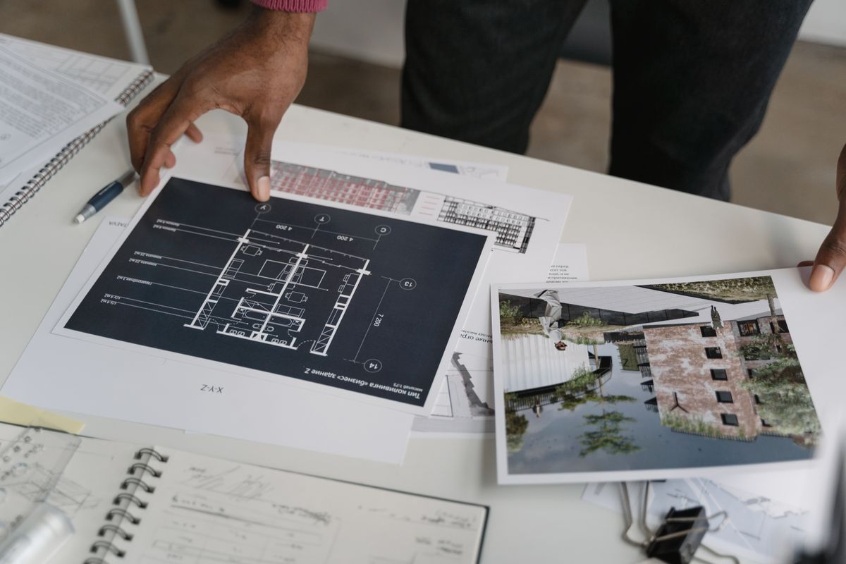 Hands reviewing drawings and documents on a desk